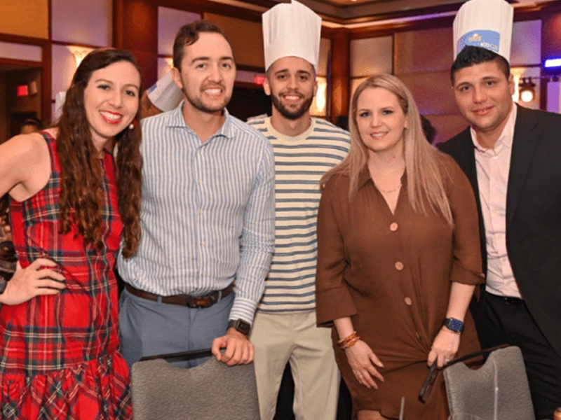 five people smiling and posing at the camera