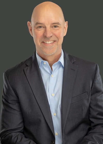 A closeup of a man, he smiles at the camera