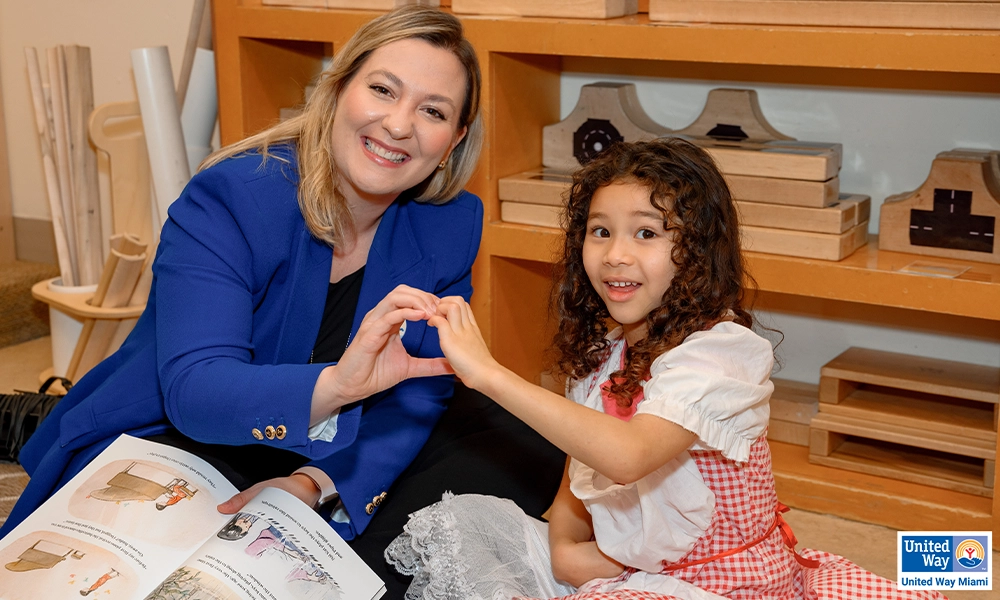 woman and girl making a heart shape with their hands