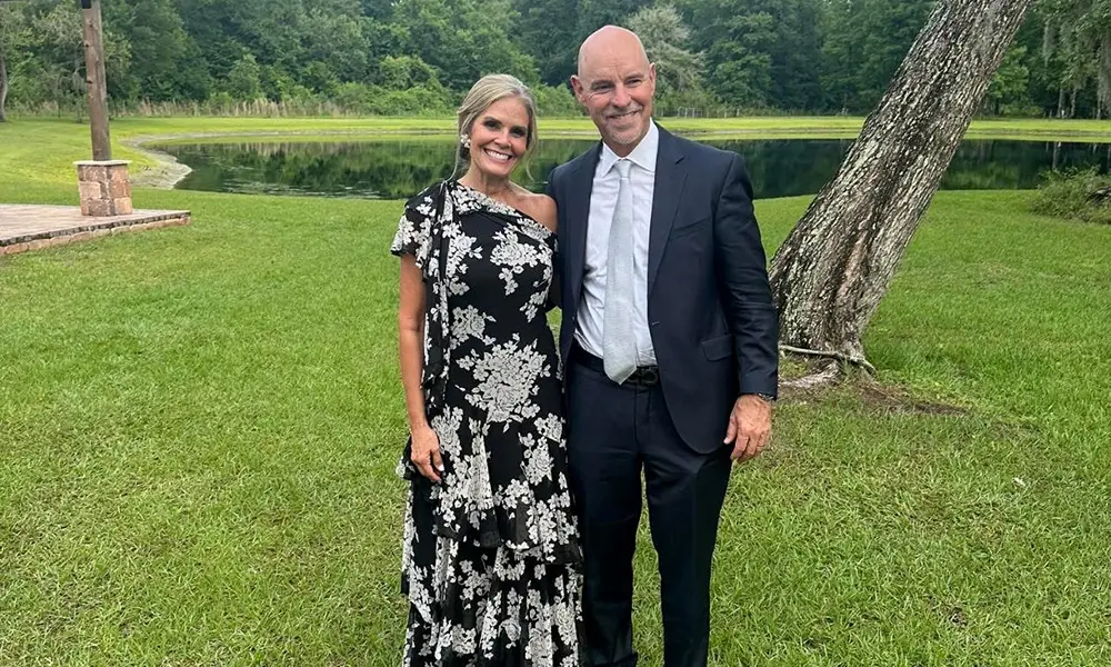Photo of a couple dressed in formal attire in the middle of a meadow